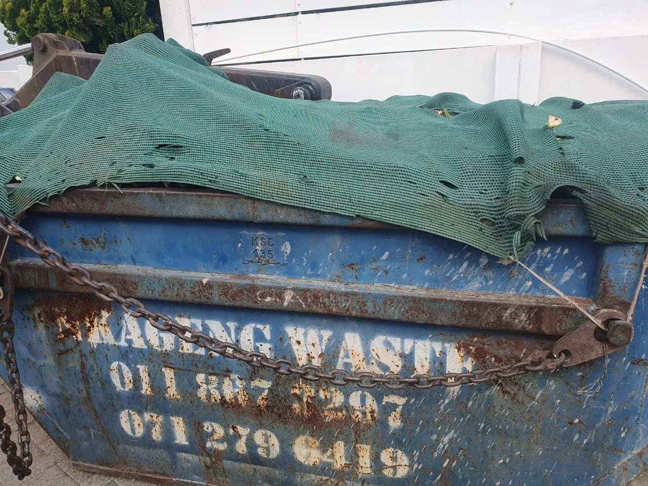 Nkageng Waste blue skip covered with a safety net